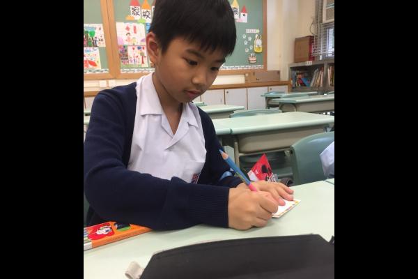 「伴我同遊」成長小組旨在增加學生的社交能力，運用不同的遊戲和活動，讓學生能夠互相合作，明白群體的重要性。左圖中學生專心設計自己的名牌。